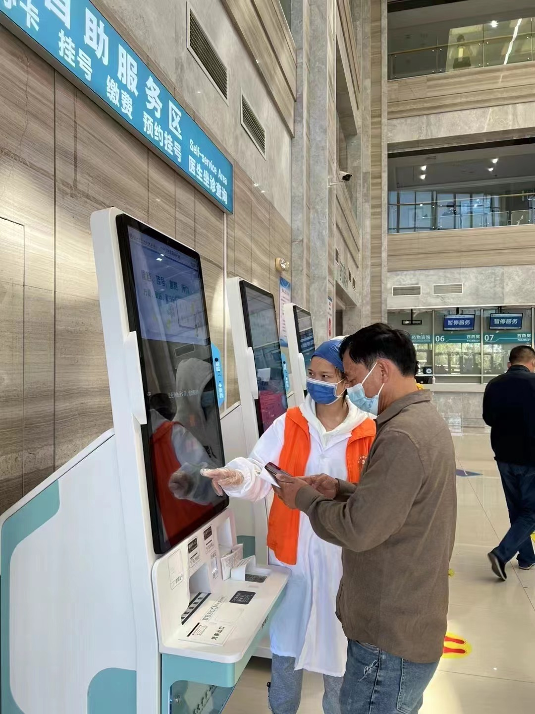 “橙心助老”小帮手协助患者使用自助式挂号机.png